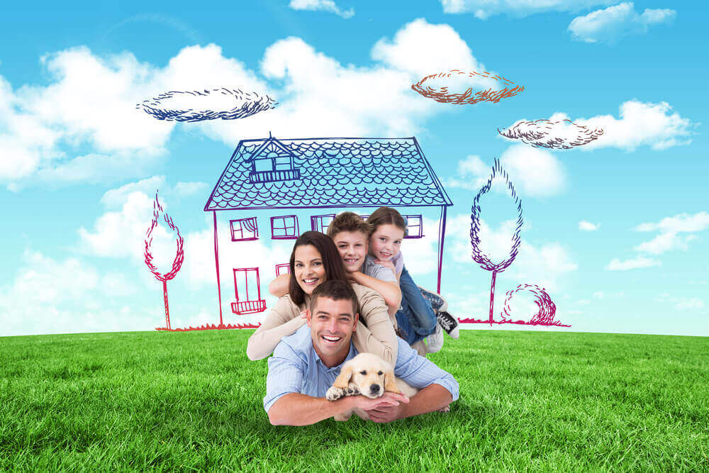 Gezin ligt op het gras voor droomhuis